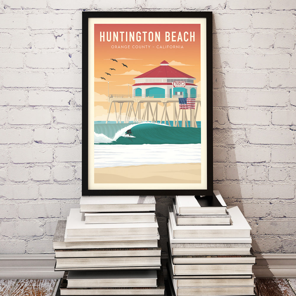 Black framed California Surfer Wall art set down on books